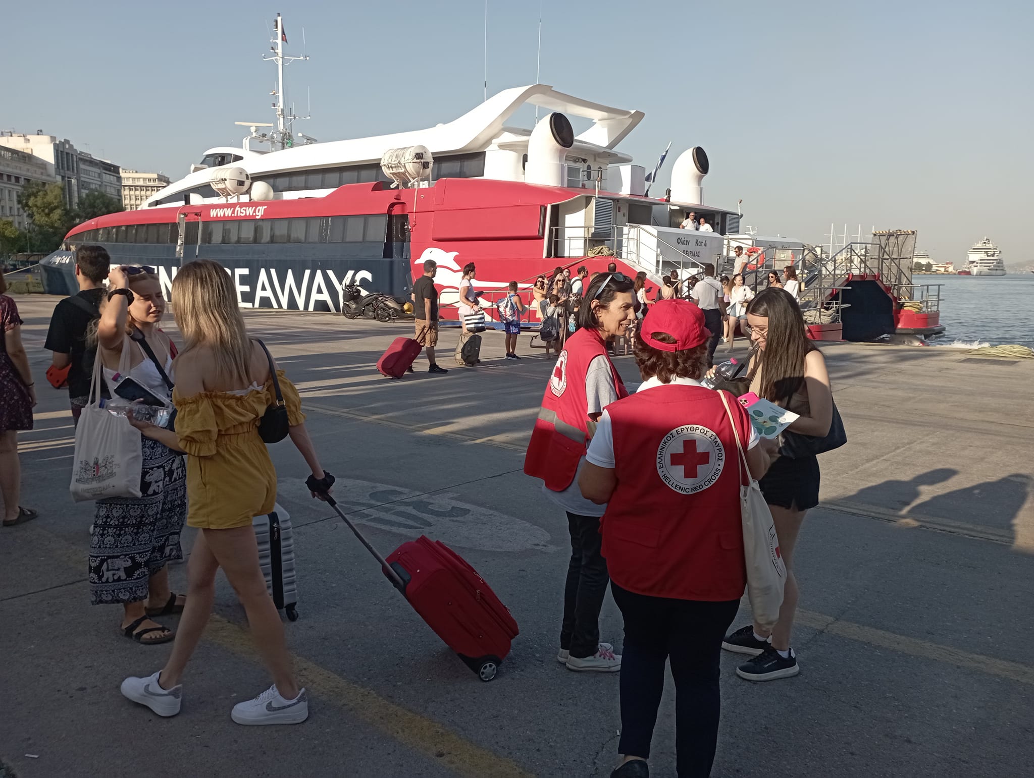 Εθελοντές του Ελληνικού Ερυθρού Σταυρού διανέμουν φυλλάδια στο λιμάνι του Πειραιά