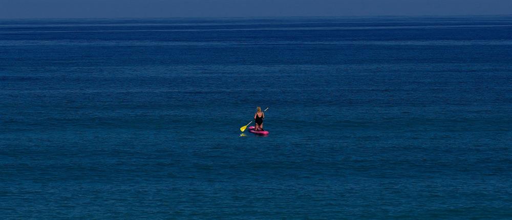 Γυναίκα κάνει SUP μέσα στη θάλασσα
